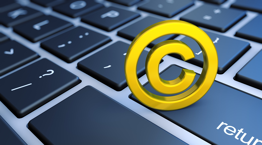 A golden copyright symbol on a dark blue computer keyboard with a return key visible.