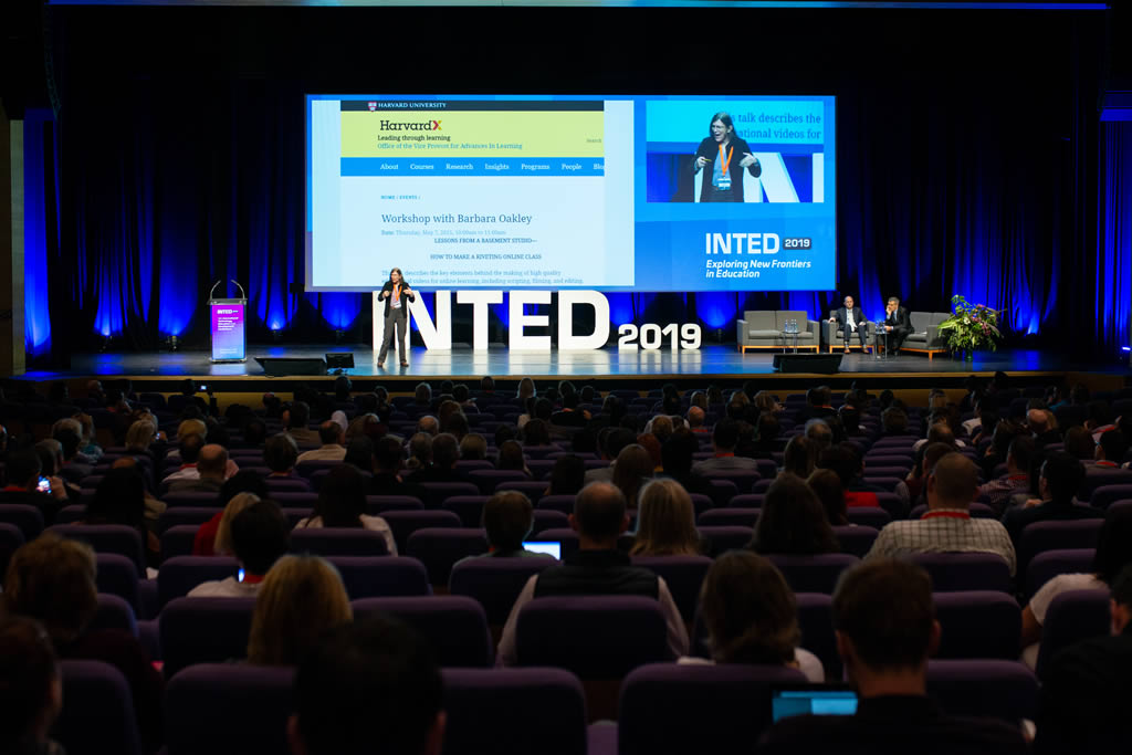 A speaker on stage at the INTED 2019 conference, with a large audience in front of them.