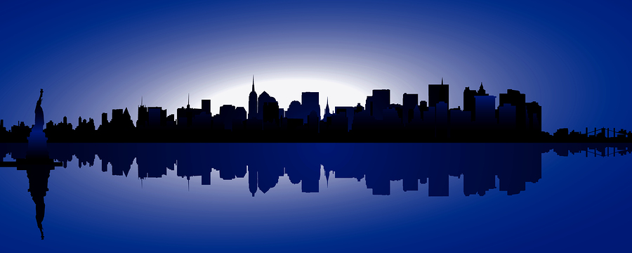 New York City skyline at dusk with the Statue of Liberty and reflections on water