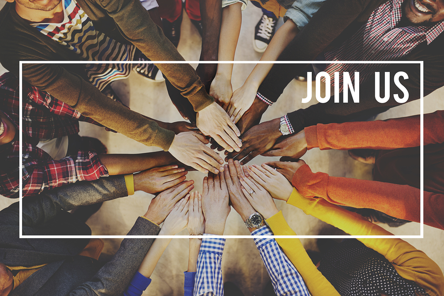 Diverse group of people with hands stacked on top of each other, with the text "JOIN US" overlaid.