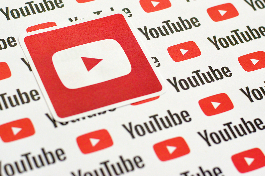 Close-up of multiple YouTube logos and text on a white background, with one larger logo in the foreground.