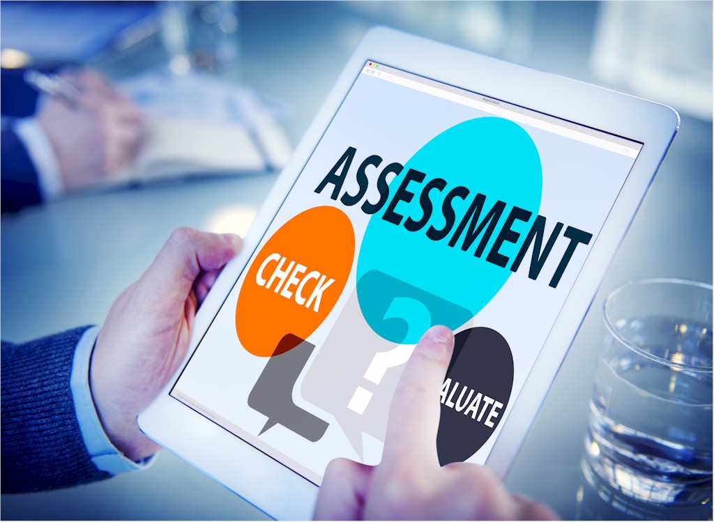 A person holding a tablet displaying the word ASSESSMENT and options like CHECK and EVALUATE.