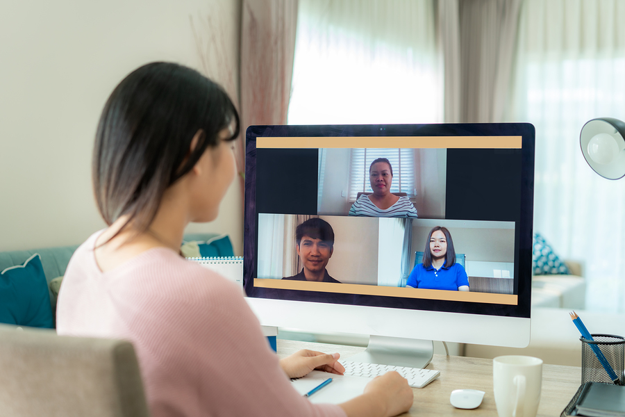 Woman on a video call with three other people on her computer screen, working from home.