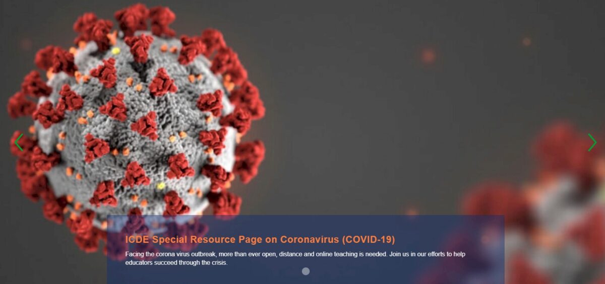 A close-up of a coronavirus model with red spikes on a grey background, with text overlay.