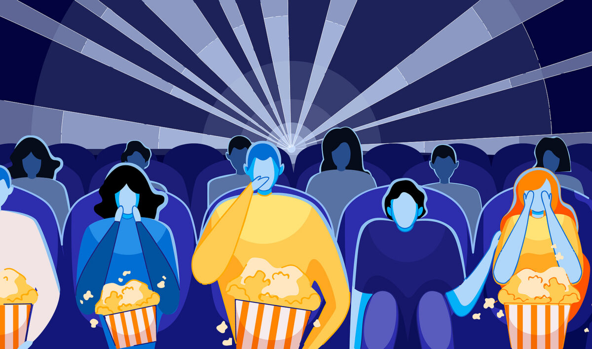 People in a dark cinema watching a film, some covering their eyes, others eating popcorn.