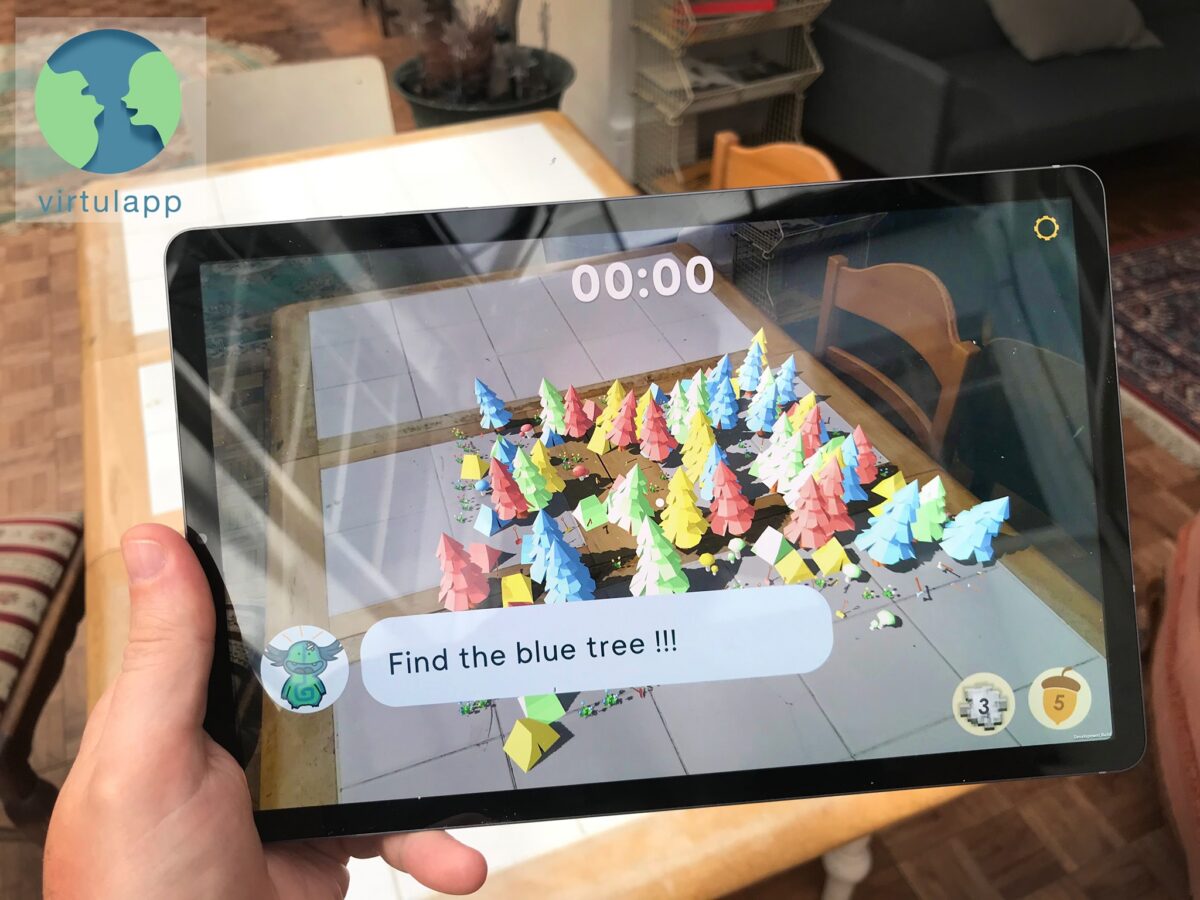 A person holding a tablet displaying an augmented reality game with colourful trees and a timer.