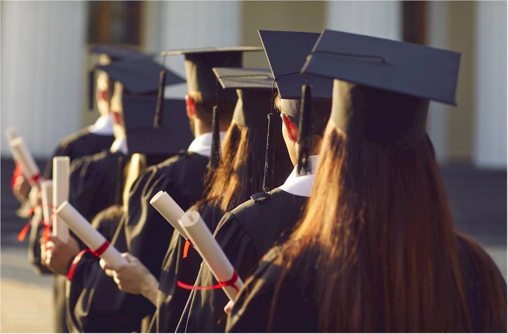 Graduates in caps and gowns, seen from behind, holding rolled-up diplomas tied with red ribbons.