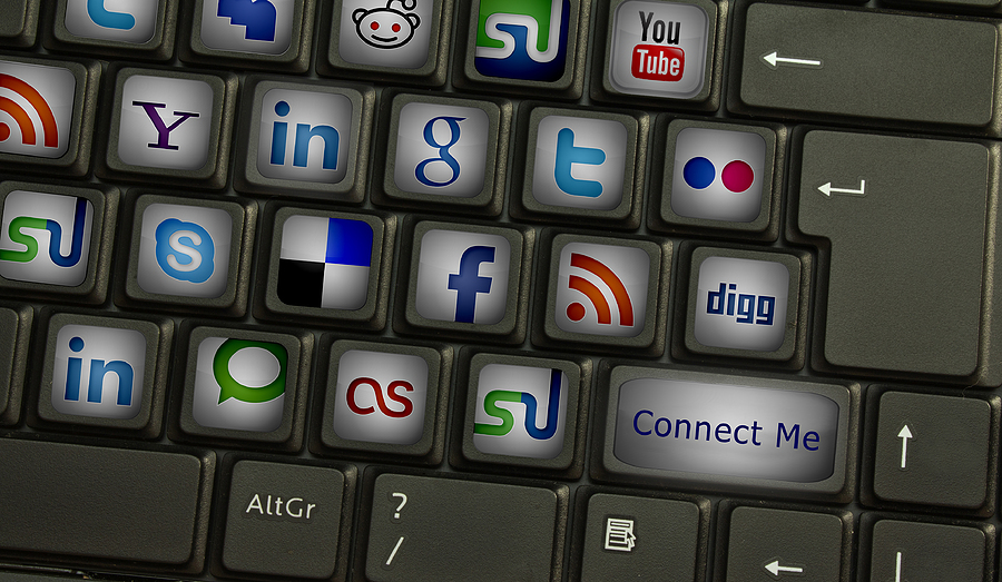 Close-up of a computer keyboard with social media logos on keys and a 'Connect Me' button.