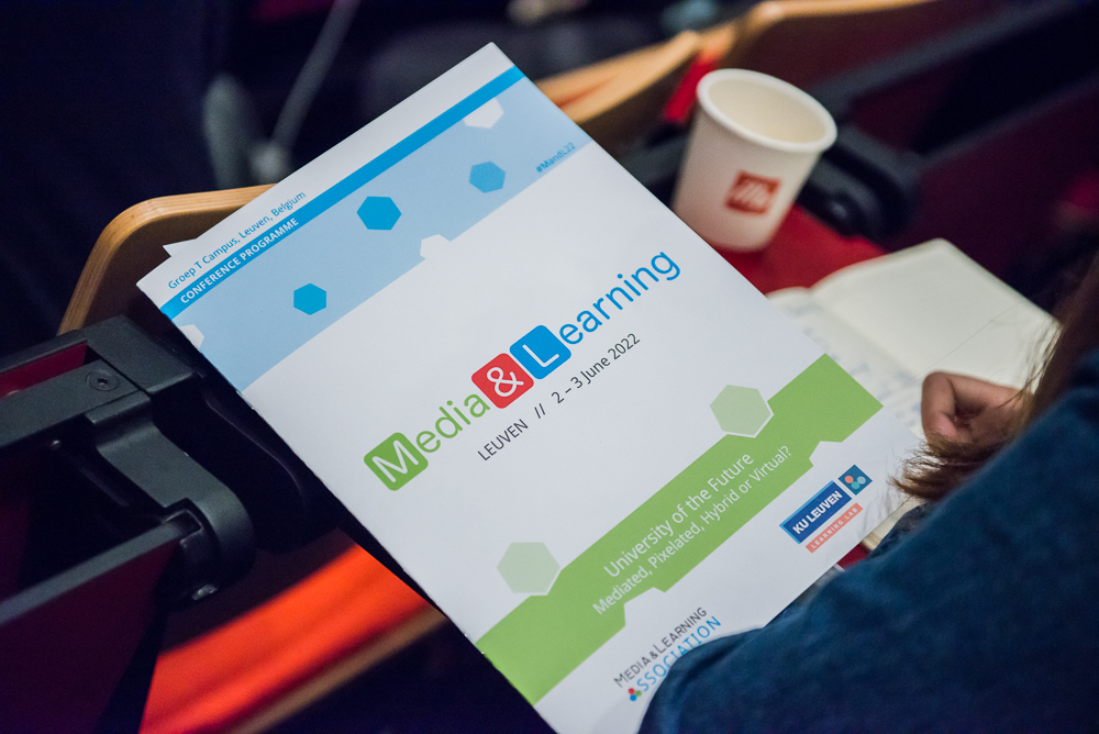 Conference programme for Media & Learning 2022, Leuven, 2-3 June, with a coffee cup in the background