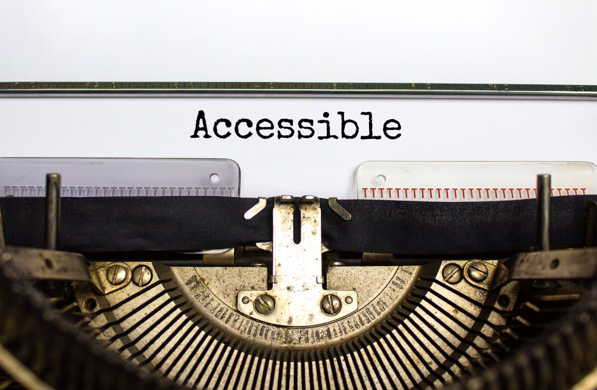 The word "Accessible" typed in black on a white sheet of paper in an old-fashioned typewriter.