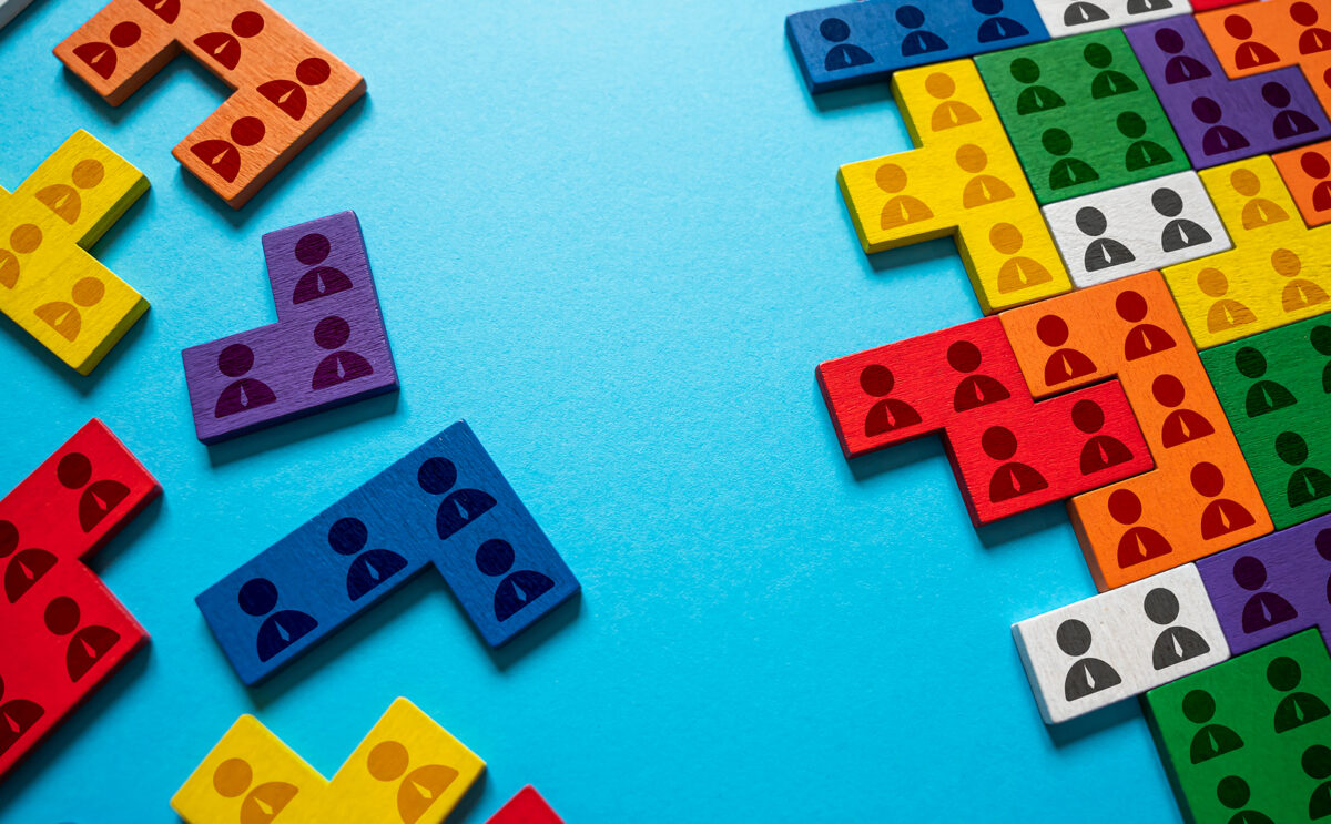Colourful puzzle pieces with human icons, some connected, some separate, on a blue background.