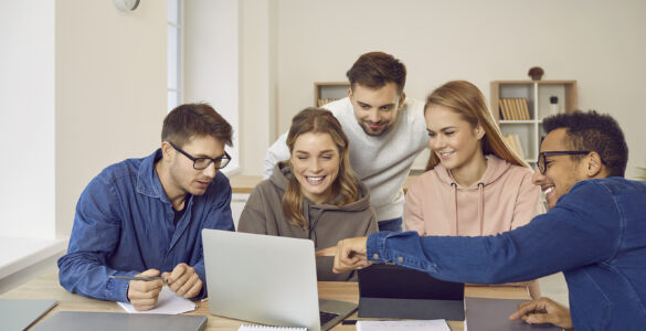 University students using a laptop computer while working on their group project