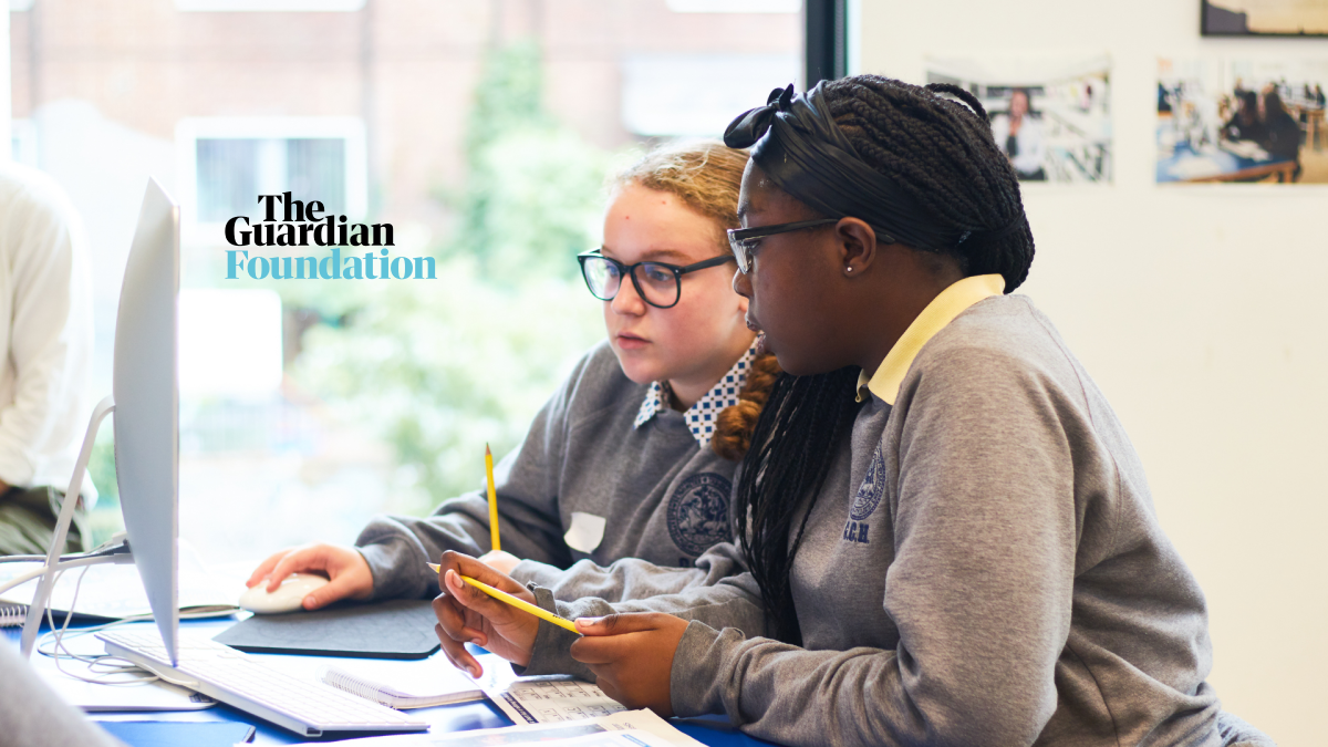 Two students, one with glasses, looking at a computer screen, with The Guardian Foundation logo.