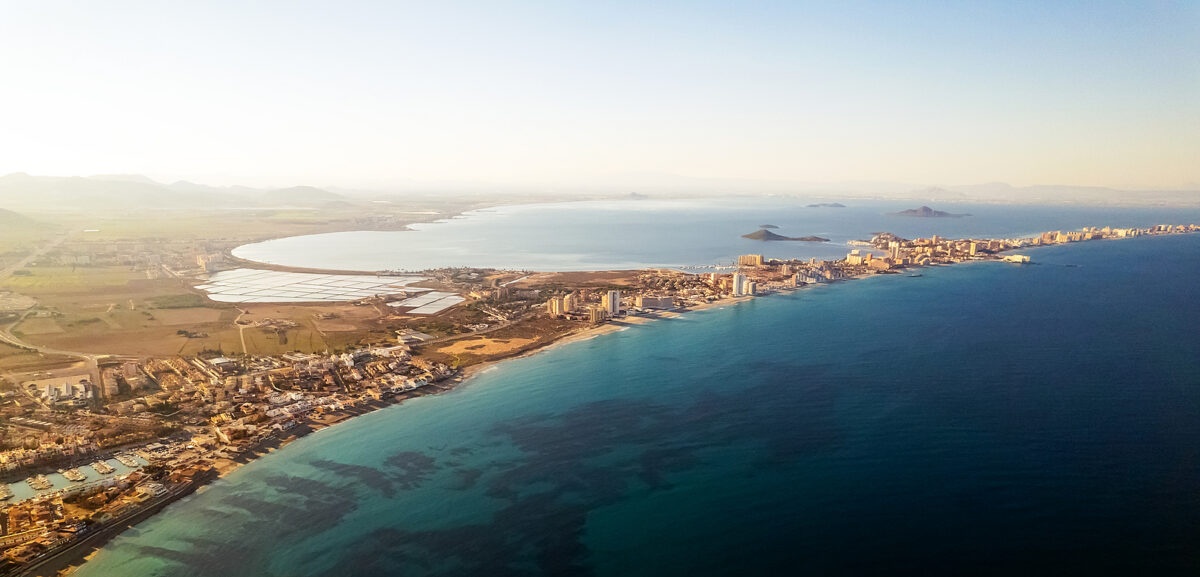 Aerial view of La Manga, Spain, a long, narrow strip of land with buildings, between two bodies of water.