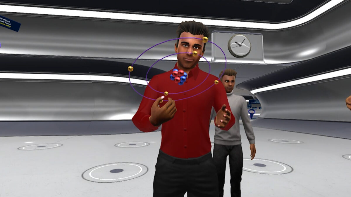 Two male avatars in a virtual reality classroom, one holding a 3D model of an atom.