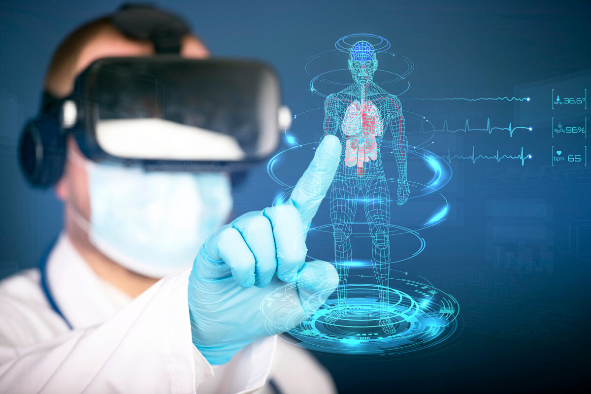 A doctor wearing a VR headset and surgical mask interacts with a holographic human body showing internal organs.