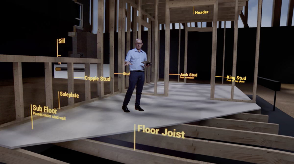 A man stands in a virtual reality model of a house frame, with parts labelled: Sill, Cripple Stud, Soleplate, Sub Floor,