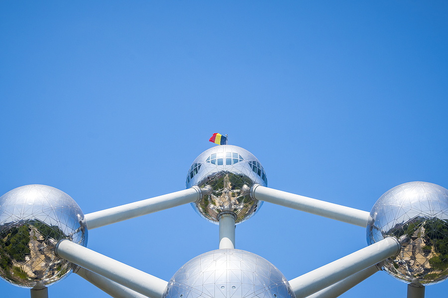 The Atomium in Brussels, Belgium, a large silver structure of interconnected spheres, against a blue sky.