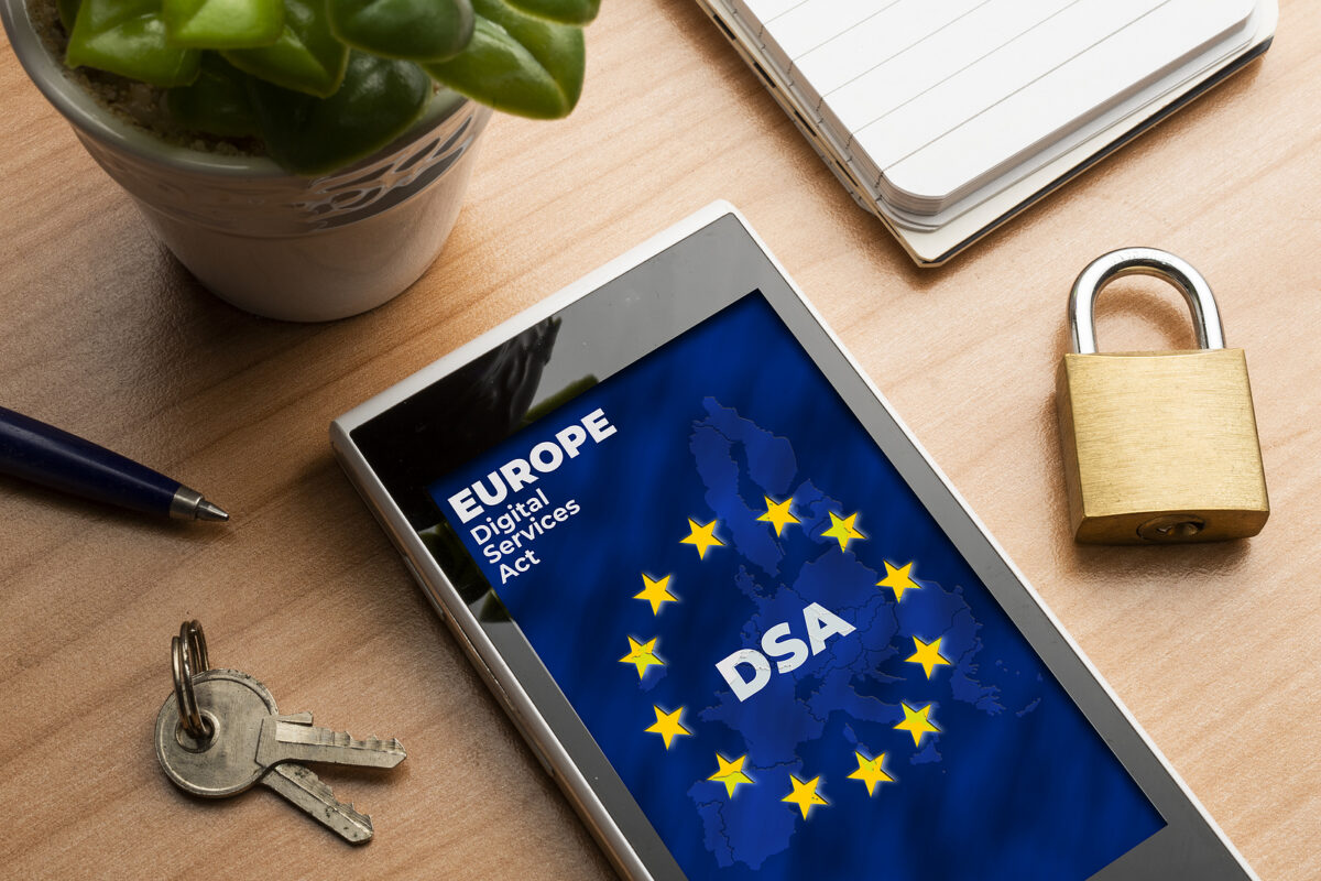 Tablet displaying the EU flag with 'EUROPE Digital Services Act' and 'DSA', next to keys and a padlock