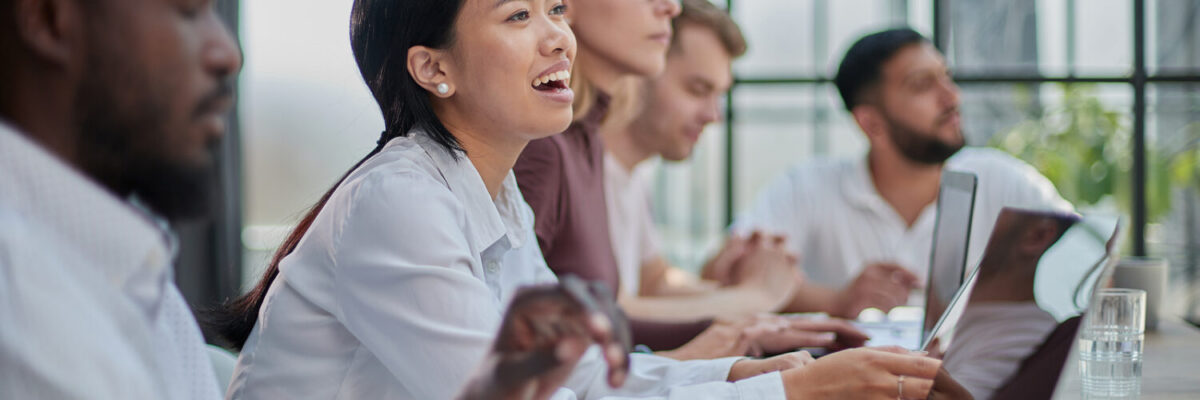 Diverse group of people, including an Asian woman, attending a webinar or conference.