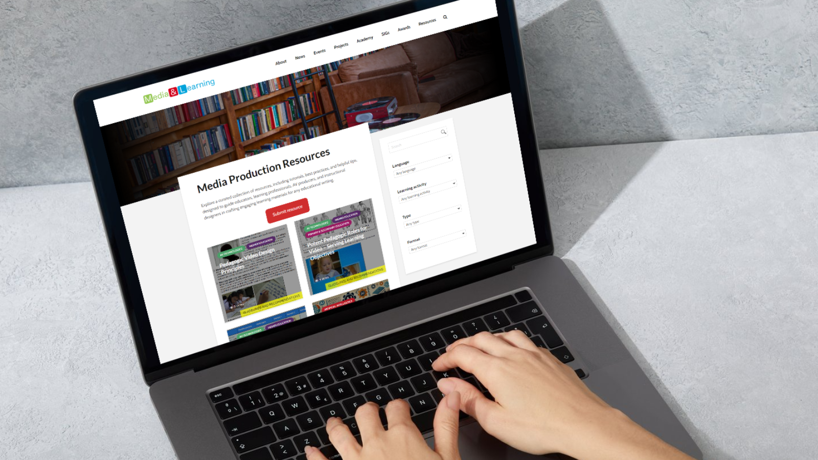 Laptop displaying the Media Production Resources Hub website with hands typing on the keyboard.
