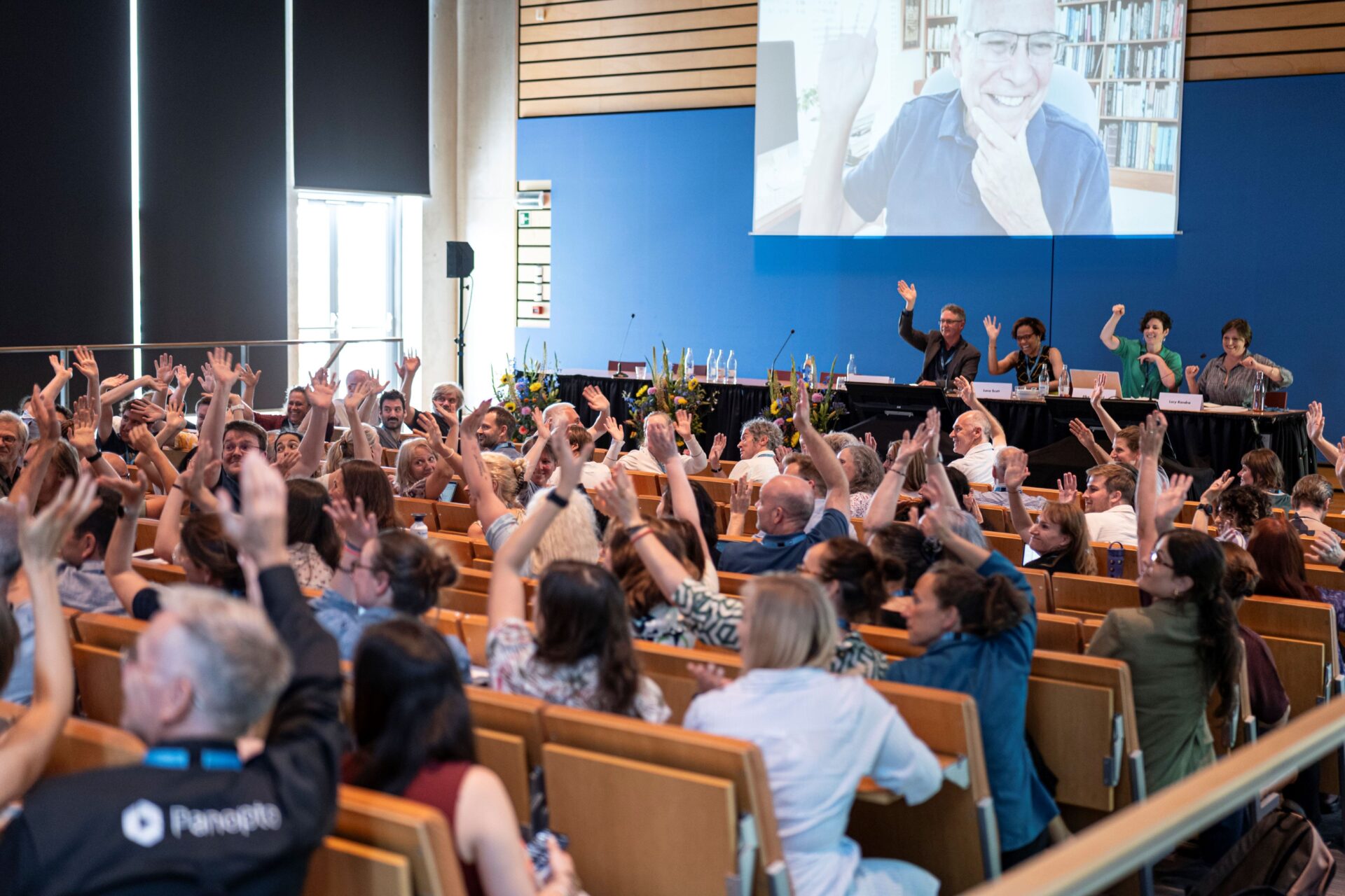 photo from the media & learning conference, auditorium, people waving